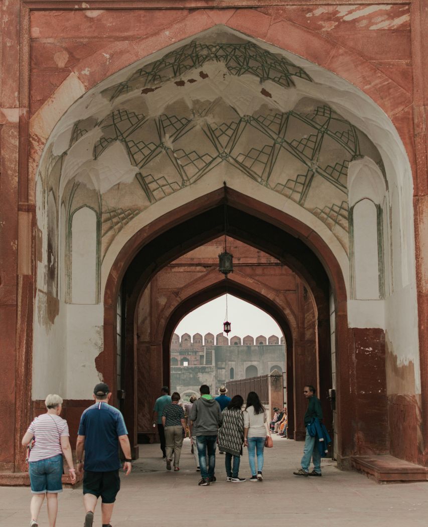 Agra Fort a group of people walking under an archway -Places to visit in Agra