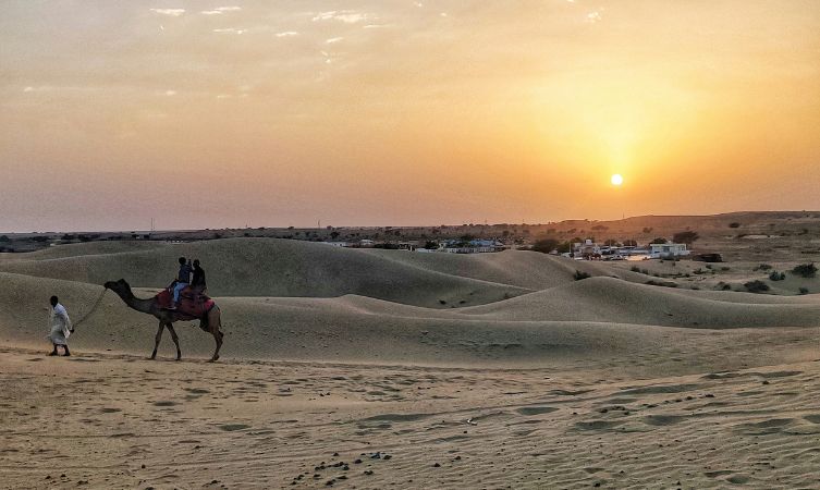 Desert in Jaisalmer two people riding a camel in the desert